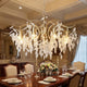Elegant modern chandelier illuminating a luxurious dining room, showcasing a blend of style in modern vs traditional chandeliers.