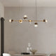 Modern chandelier for dining ambiance featuring stylish glass globes and a sleek gold frame.