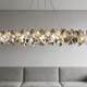 Stunning crystal chandelier above a modern gray sofa in an elegant living room, showcasing styles in the buyer's guide to crystal chandeliers.