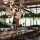 Modern restaurant interior showcasing commercial lighting trends for restaurants and vibrant greenery.